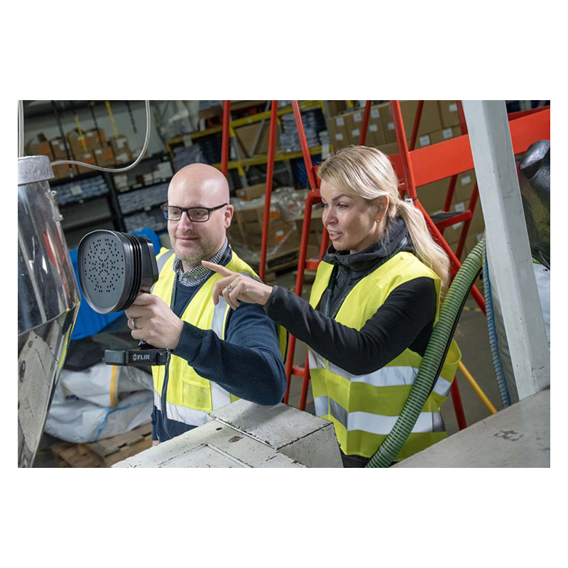 Man and woman using the FLIR Si1-LD Acoustic Camera to inspect equipment.
