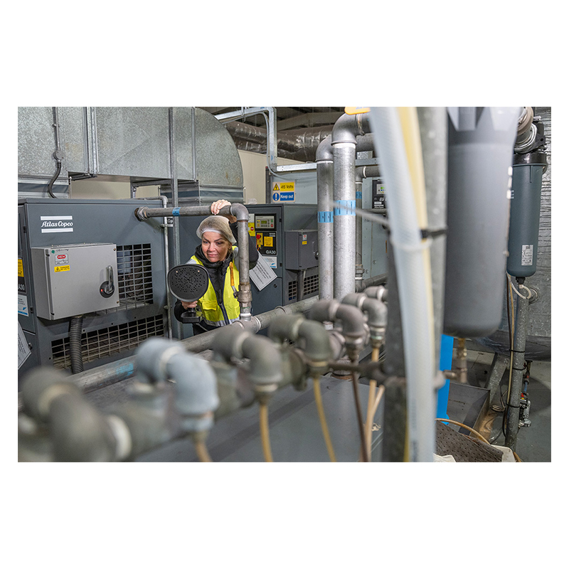 Lady using a FLIR Si1-LD Acoustic Camera to inspect mechanical equipment 